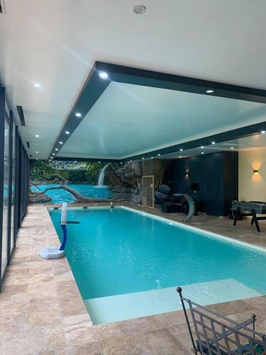 une grande piscine dans une maison dans l'établissement Chalet authentique à Clermont-Créans avec piscine partagée, à La Flèche