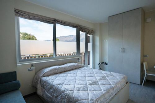 - une chambre avec un lit et une grande fenêtre dans l'établissement RESIDENCE VILLA ELI, à Côme