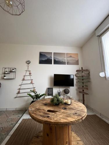Habitación con mesa de madera en una habitación en Les Salines, en Montmorot