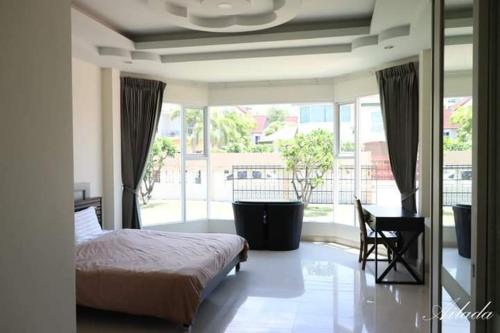 1 dormitorio con cama, escritorio y ventana en Wonderland pool villa en Pattaya centro