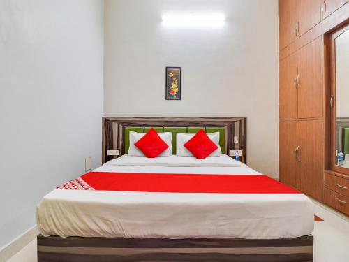 a bedroom with a large bed with red pillows at Hotel D.Homage in Dehradun