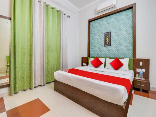 a bedroom with a large bed with red pillows at Hotel D.Homage in Dehradun