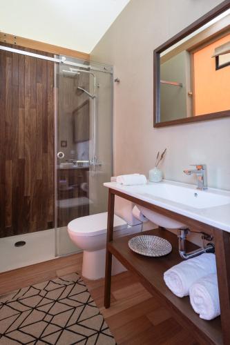 a bathroom with a sink and a toilet and a shower at iHouseVILLAGE in Polykhrono