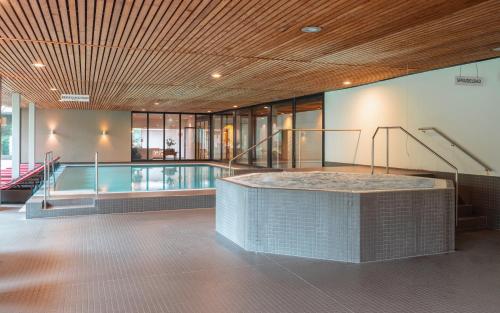 a building with a swimming pool and a staircase at Gesundhotel Bad Reuthe in Vorderreuthe