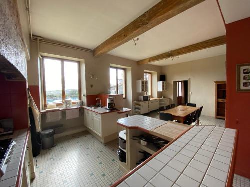 uma cozinha com um balcão e uma mesa em Villa de 5 chambres avec piscine privee jardin amenage et wifi a La Croix Blanche em La Croix-Blanche