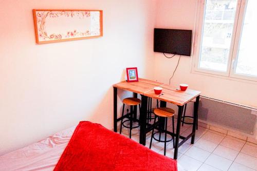 Cette chambre dispose d'une table avec tabourets et d'une télévision. dans l'établissement Proche rempart avec Parking sécurisé, à Avignon