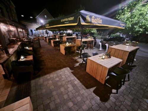 a restaurant with tables and chairs and an umbrella at Au Coeur d'Alle in Alle