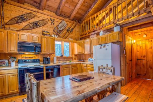 cocina con armarios de madera, mesa de madera y nevera en Family-Focused & Pet-Friendly Log Cabin with 4BR 2BA Sleeps 10, en Bethlehem