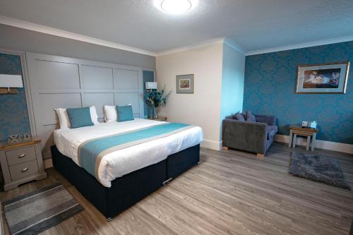 a bedroom with a large bed and a couch at Best Western Manor Hotel in Gravesend