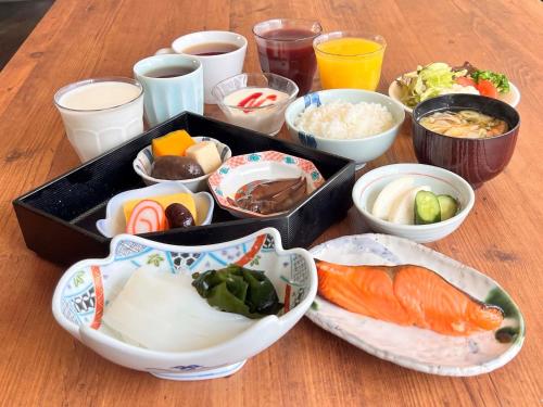 una mesa con tazones de comida sobre una mesa de madera en Kanazawa Manten Hotel Ekimae, en Kanazawa