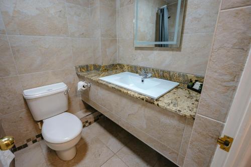 a bathroom with a toilet and a sink at Best Western Manor Hotel in Gravesend