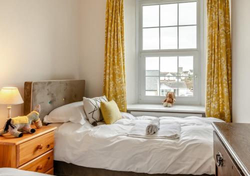 a bedroom with a bed and a window with a teddy bear at Mailscot in Mortehoe
