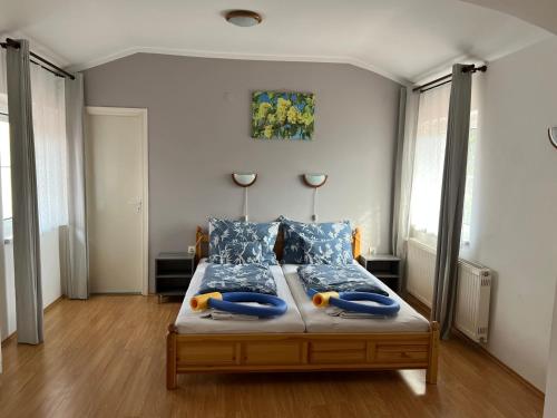 - une chambre avec un lit et 2 oreillers bleus dans l'établissement Magic Garten, à Hévíz