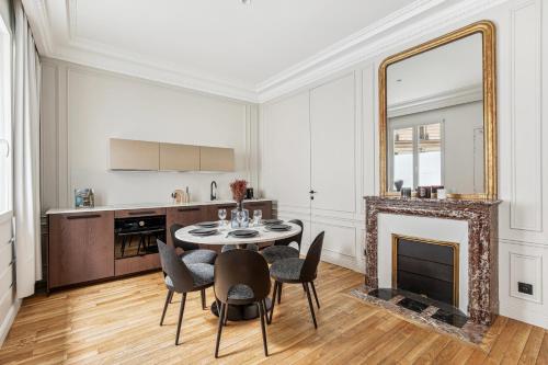 - un salon avec une table, des chaises et un miroir dans l'établissement Interior Design - Apartment 6P-1BR - Tour Eiffel, à Paris