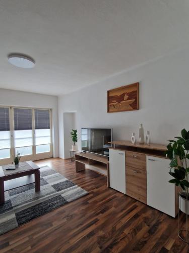 a large living room with a table and a tv at Haus Kampl - Appartement Ödensee in Obersdorf