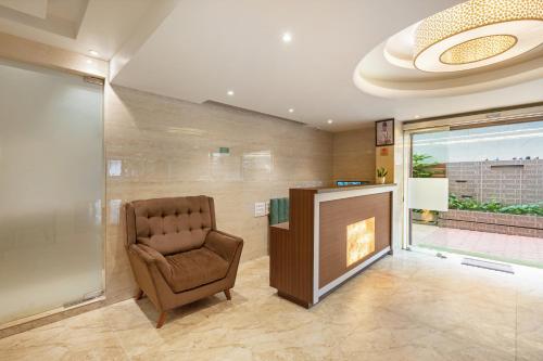 a waiting room with a chair and a fireplace at Treebo Sunheads in Panaji