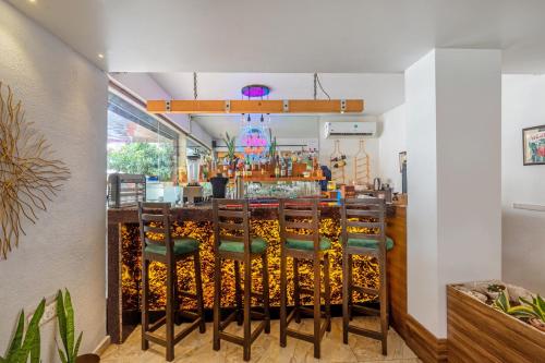 a bar with green chairs at a restaurant at Treebo Sunheads in Panaji