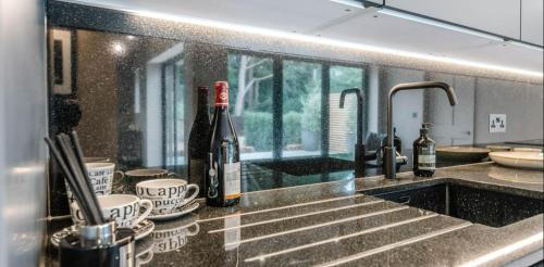 una cocina con 2 botellas de vino en una barra en The Lodge, Saxmundham en Saxmundham