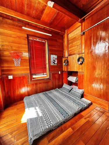 歸仁的住宿－Biệt thự gỗ Wooden House Quy Nhơn cạnh biển，木制客房的一张床位,配有篮球架