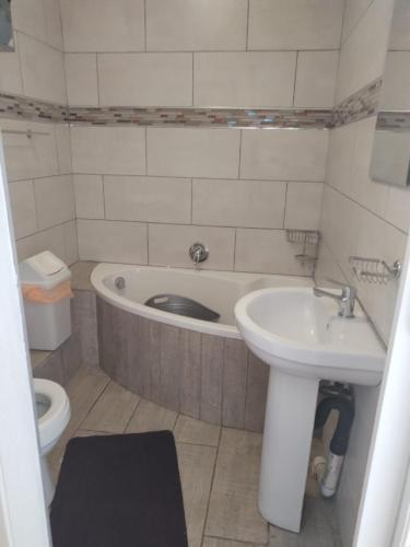 a bathroom with a tub and a sink and a toilet at Chesapeake Bay 23 in Margate