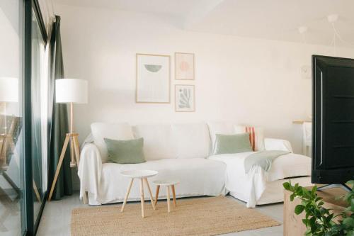 a living room with a white couch and a table at Apartamento Pemedal in Villaverde