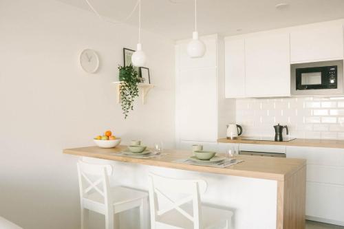 a kitchen with a counter with two stools in it at Apartamento Pemedal in Villaverde