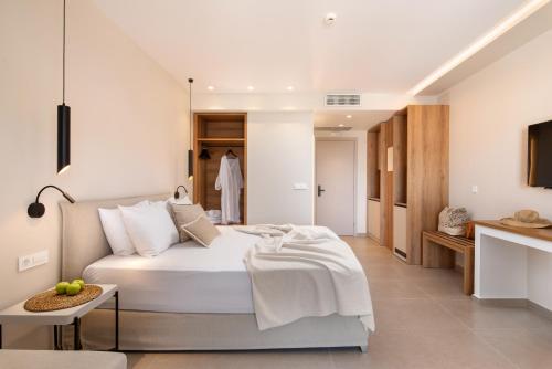 a bedroom with a white bed and a bathroom at Sofibel sivota suites in Sivota