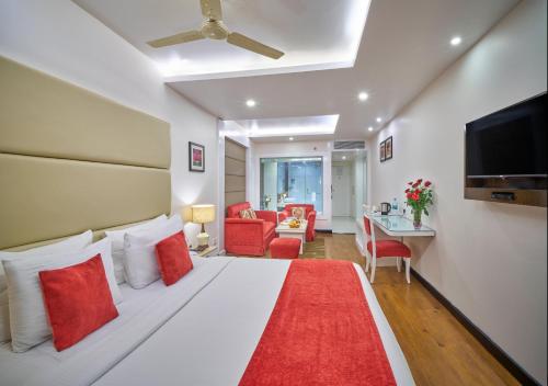 a bedroom with a large white bed with red pillows at Hotel Hindusthan International, Bhubaneswar in Bhubaneshwar