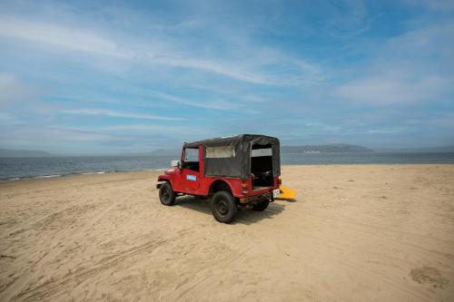 a small red jeep parked on the beach at Treebo Sunheads in Panaji