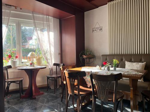 a restaurant with two tables and chairs and a window at Landhaus Pusteblume in Quedlinburg
