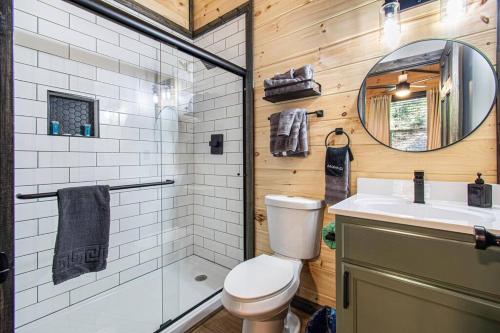 a bathroom with a toilet and a sink and a mirror at Hot Tub, Games, Fireplace & Fast WiFi Near Dollywood in Sevierville