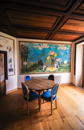 une salle à manger avec une table, des chaises et un grand tableau dans l'établissement Chateau de Saint Dau, à Figeac