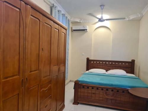 a bedroom with a bed and a wooden cabinet at Home Stay Boutique Zanzibar in Stone Town