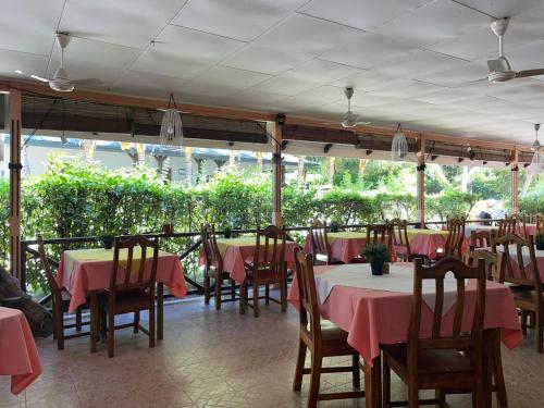 a restaurant with tables and chairs with pink tablecloths at Chez Marston in La Digue