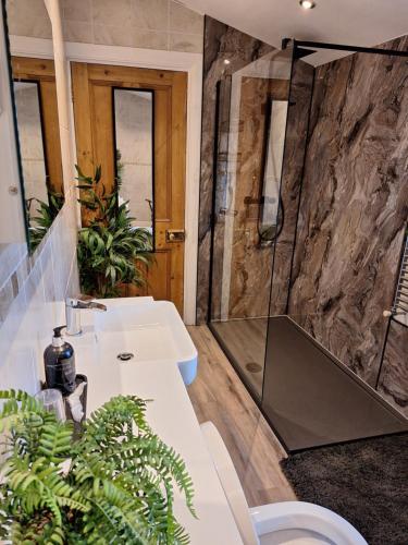 a bathroom with a sink and a shower at Slate Hall in Seahouses