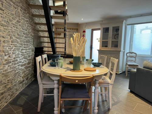 einen Esstisch mit Stühlen und eine Ziegelwand in der Unterkunft Jolie maison de ville, vue mer in Le Conquet