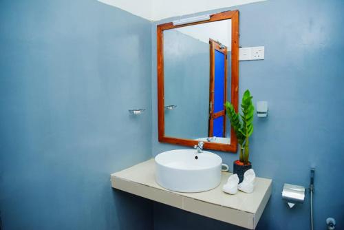 Lily Resort Udawalawe في اوداوالاوي: حمام مع حوض أبيض ومرآة