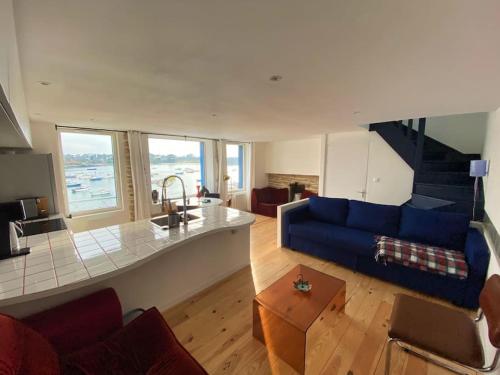 un salon avec un canapé bleu et une table dans l'établissement Vue imprenable sur le port, à Ploudalmézeau