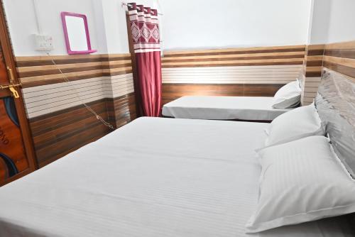 سرير أو أسرّة في غرفة في Vaidehi Home Stay