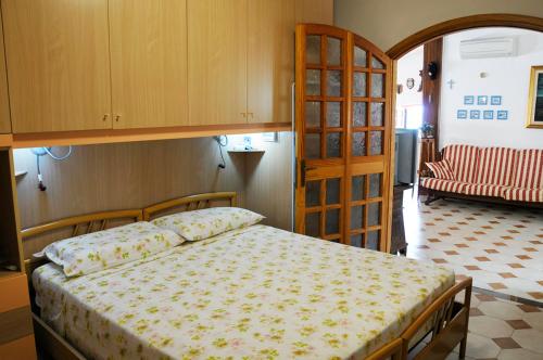 una camera con letto, armadio e divano di Comodo e ampio appartamento fronte mare in Loc. Maladroxia C535 a Maladroscia