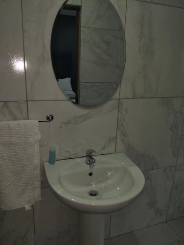 a white sink in a bathroom with a mirror at Van Dyk guest house in Boksburg