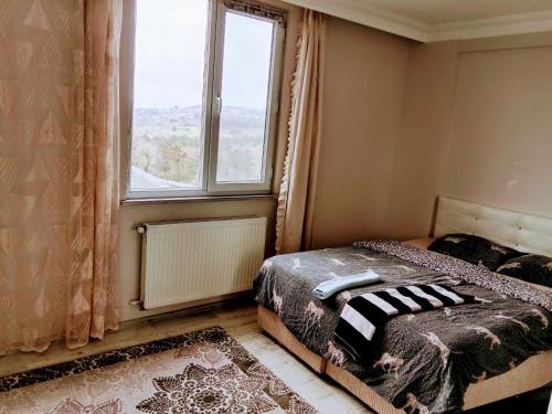a bedroom with a bed and a large window at forest villa-2, 5 minutes from Istanbul airport in Taşoluk