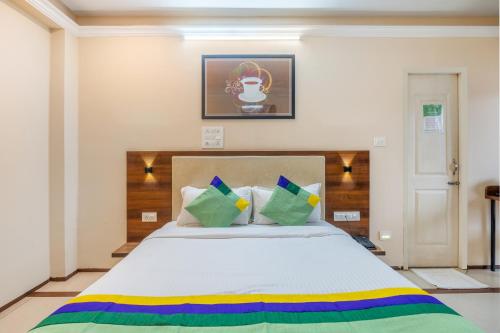 a bedroom with a large white bed with colorful pillows at Treebo Sunheads in Panaji