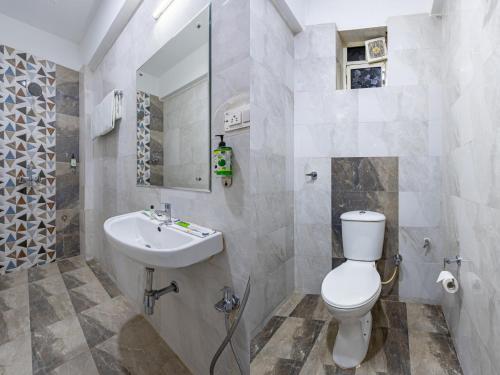 a bathroom with a white toilet and a sink at Treebo Sunheads in Panaji