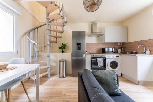 a kitchen and living room with a spiral staircase at * Le Cocon * Centre-ville Douai-500m place d'Armes in Douai
