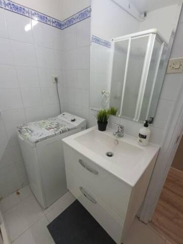 a white bathroom with a sink and a mirror at Apartamento San Antón in Huesca