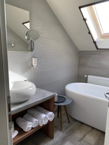 a bathroom with a white tub and a sink at Cetatuia in Măgura