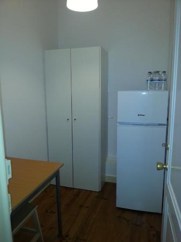 a kitchen with a white refrigerator and a table at Residência Almirante in Lisbon