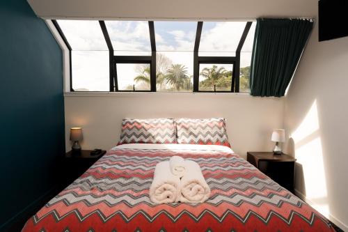 1 dormitorio con 1 cama con 2 toallas en Haka Lodge Bay of Islands (Paihia), en Paihia