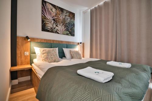 a hotel room with two beds with towels on them at Apartamenty Laguna Beskidów - B39 in Zarzecze